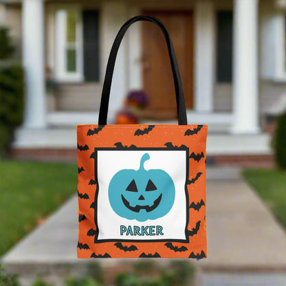 Halloween-themed tote bag with a blue pumpkin design and text, placed on a porch.