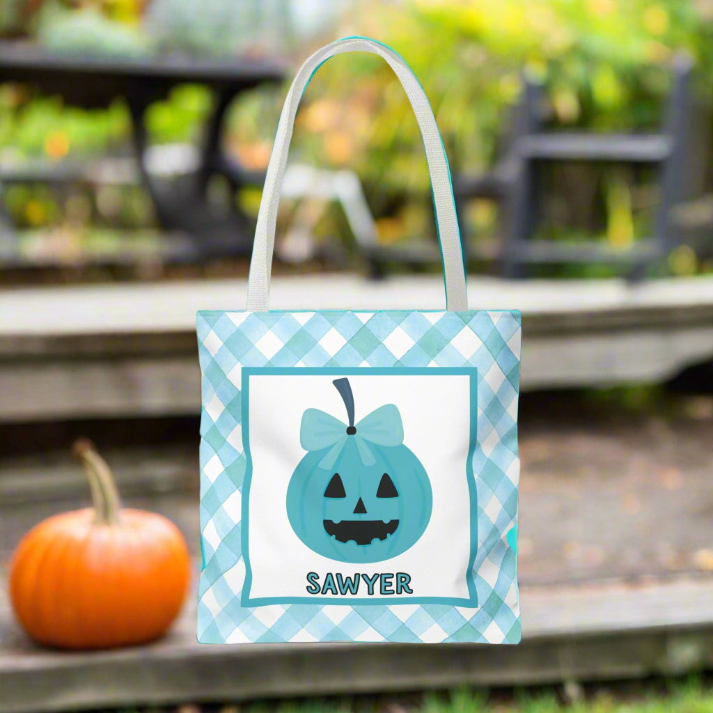 Halloween-themed teal and white tote bag with a pumpkin design and text.