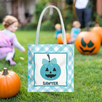Halloween-themed tote bag with a pumpkin design and name on a teal check background.
