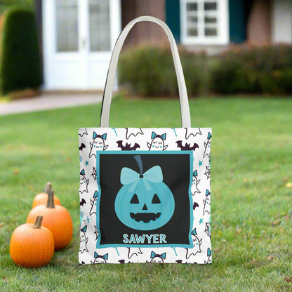 Halloween-themed tote bag with a ghost and pumpkin design and name on a white and teal background.