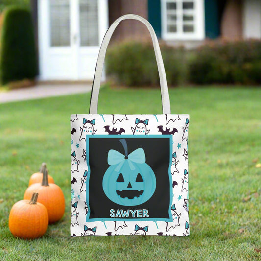 Halloween-themed tote bag with a ghost and pumpkin design and name on a white and teal background.